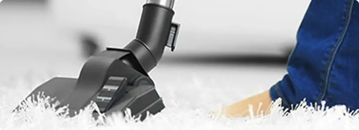 Close-up of a professional vacuuming a white carpet in Sunset Beach.